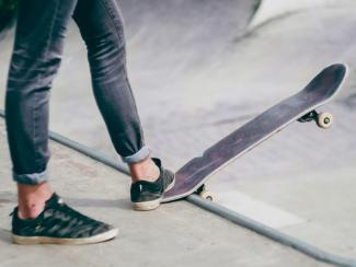 Person on a skateboard at the top of a concrete skate ramp